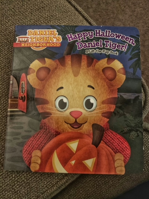 Picture of the book Happy Halloween Daniel Tiger. Daniel Tiger is holding a pumpkin in his front yard. 